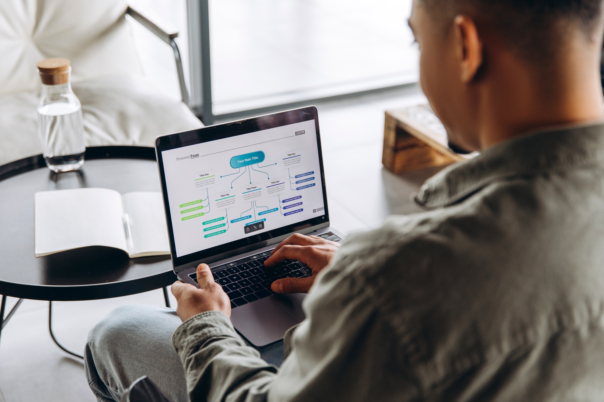 Businessman working on flowchart presentation on laptop in modern office