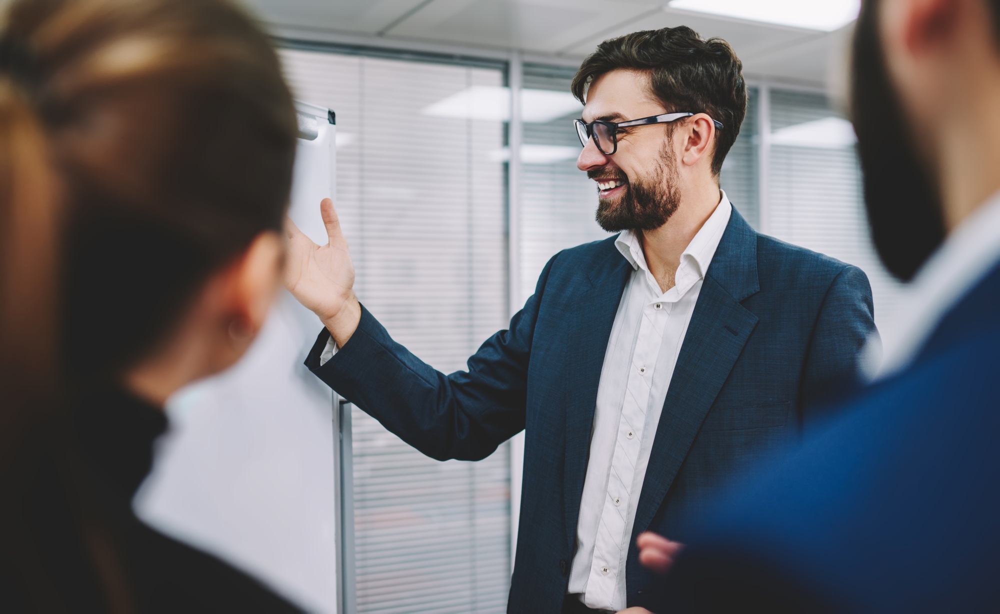 Cheerful entrepreneur presenting business plan to colleagues