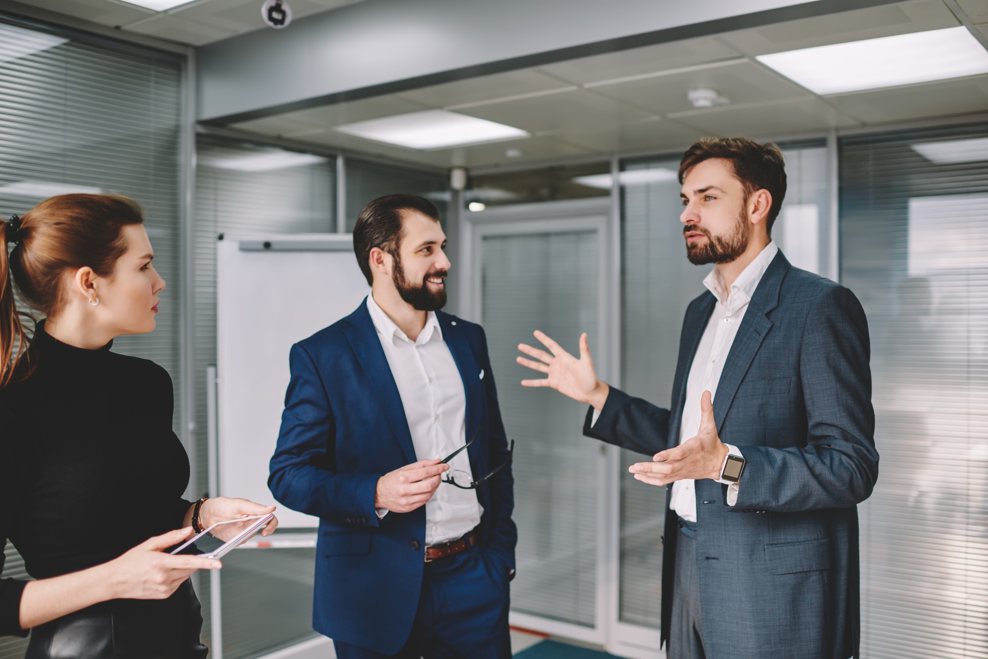 Serious businessman explaining strategy to colleagues in spacious workspace